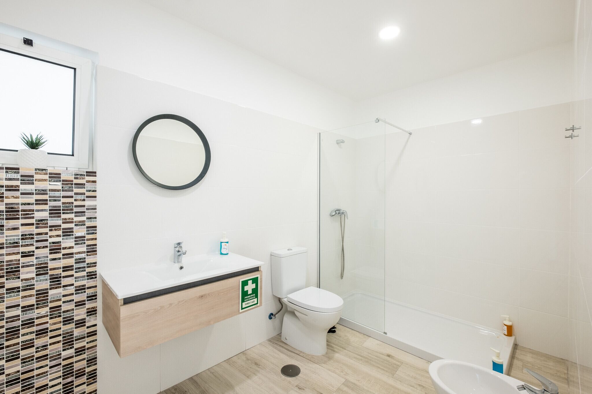 Une salle de bain moderne équipée de toilettes, d’un lavabo et d’une douche.