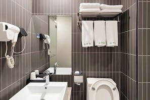 A modern bathroom with a sink, toilet, towel rack, and hairdryer.