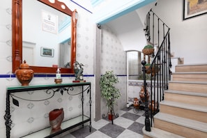 Stunning lobby with a checkered floor, wooden staircase, and elegant decor.