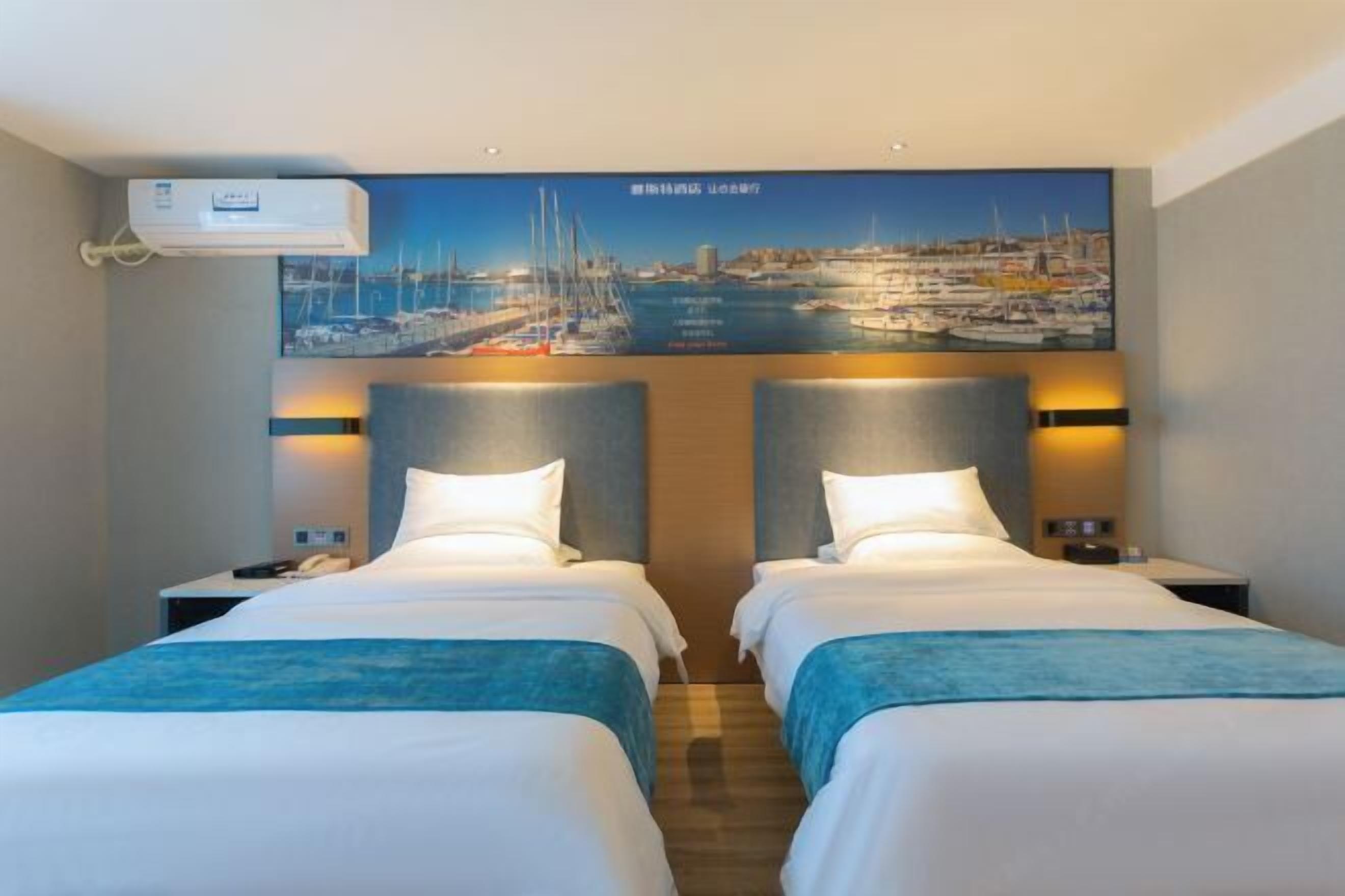 A hotel room with two beds, a painting of a marina, a wall-mounted air conditioner, and bedside lamps.