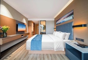 A modern hotel room with a large bed, a flat-screen TV, a desk with a phone, and a painting on the wall. - Yeste Hotel (Yulin Yudong New District Wentilu) (Yulin)