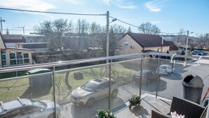 A balcony with a view of a parking lot, a house, and a clear sky. - Apartment Josip - One Bedroom apartment (Zagreb)