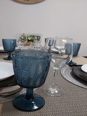 A dining table with blue glassware and clear glassware.