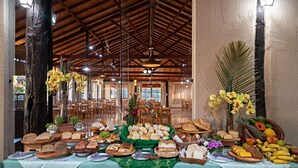 Una mesa de buffet con panes, frutas y flores variados.
