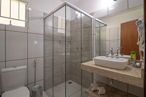 Luxe vierpersoonskamer | Badkamer | Een haardroger, handdoeken, zeep, shampoo