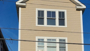 A two-story building with a garage, a wooden front door, and a wreath above the garage door.