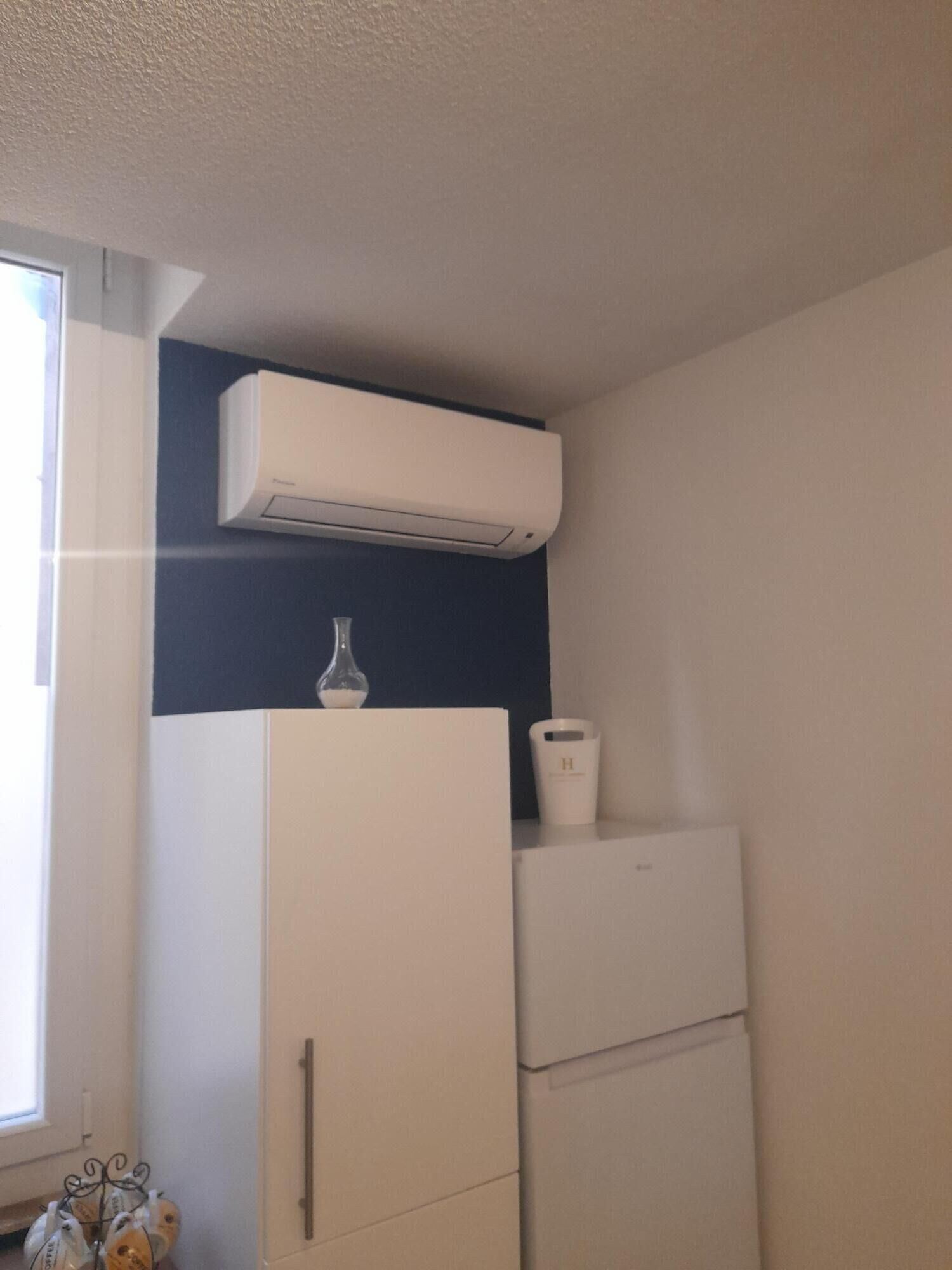Een keuken met een witte koelkast, een witte oven en een wit kastje.