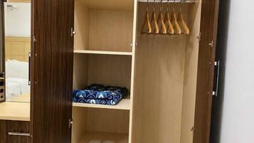 Un vestidor amplio con varias estanterías, una barra para colgar ropa y un par de zapatillas en la repisa inferior.