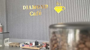 Una cocina con una encimera, una cafetera y un recipiente de vidrio con granos de café.