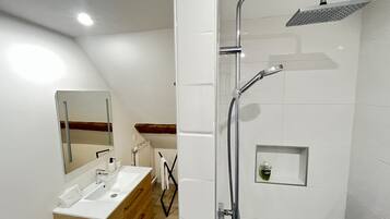Un baño moderno con ducha, lavabo y espejo.