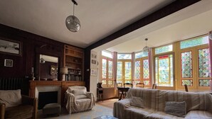 Ein gemütliches Wohnzimmer mit Kamin, einer Couch, einem Couchtisch und einem Essbereich mit Tisch und Stühlen.