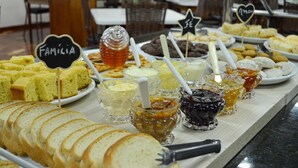 Un bufé con diversos alimentos, incluyendo pan, bollería y salsas.