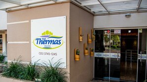 Entrada de un hotel con un cartel que indica Hotel Thomas, incluyendo un número de teléfono.