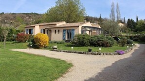 A house with a garden, a gravel driveway, and a stone border. - House Les Hortensias (MONTAUROUX)
