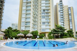 A swimming pool surrounded by high-rise residential buildings with balconies.