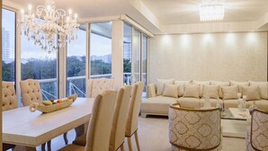 A spacious room with a dining area, a sofa set, and a chandelier. - Hermosas piscinas, solo a 5 minutos del mar y salida directa a centro comercial. (Bello Horizonte, Santa Marta)
