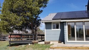 A residential building with a solar panel roof, a deck, and a large window. - Cozy Cottage perfect for a couple or small family (Durango)