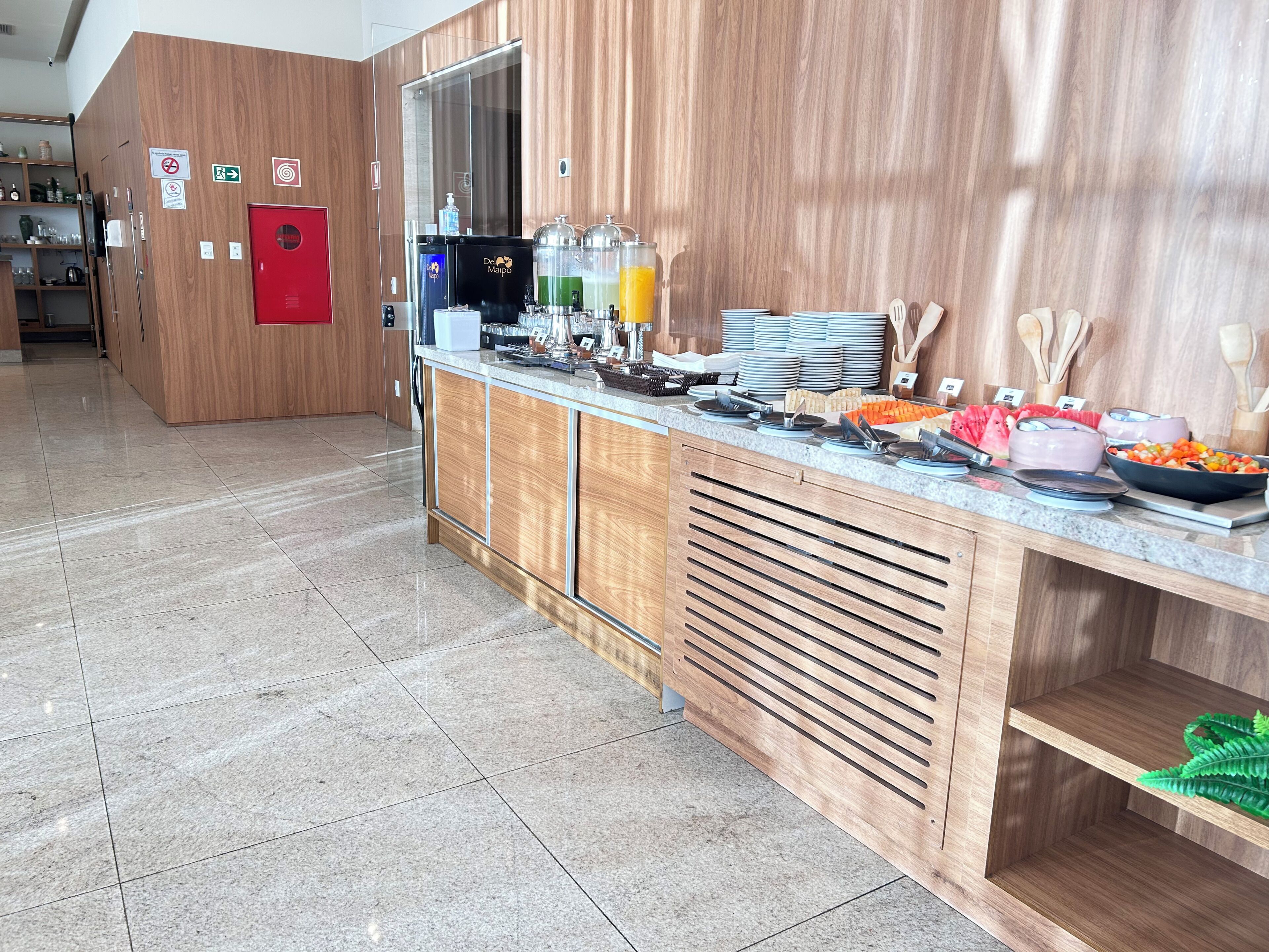 A buffet area with a variety of food items, a coffee machine, and a refrigerator.