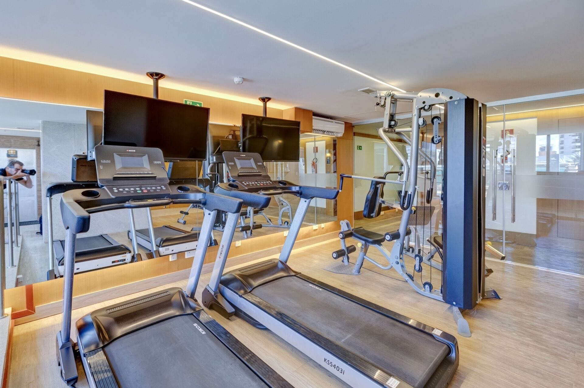 A gym with treadmills, elliptical machines, and weight equipment.