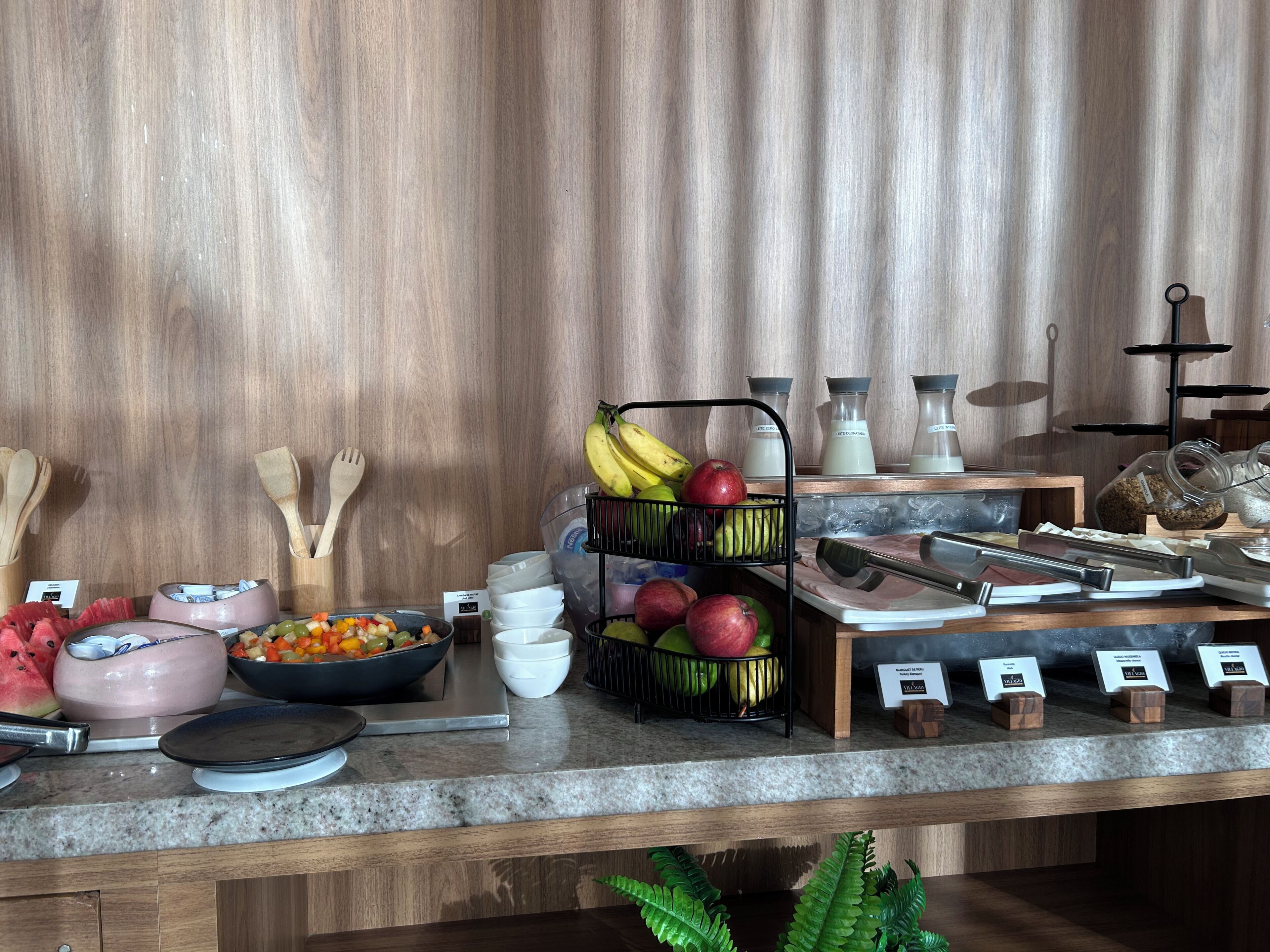 Un plan de travail de cuisine avec divers ustensiles, un panier de fruits et un coin café.