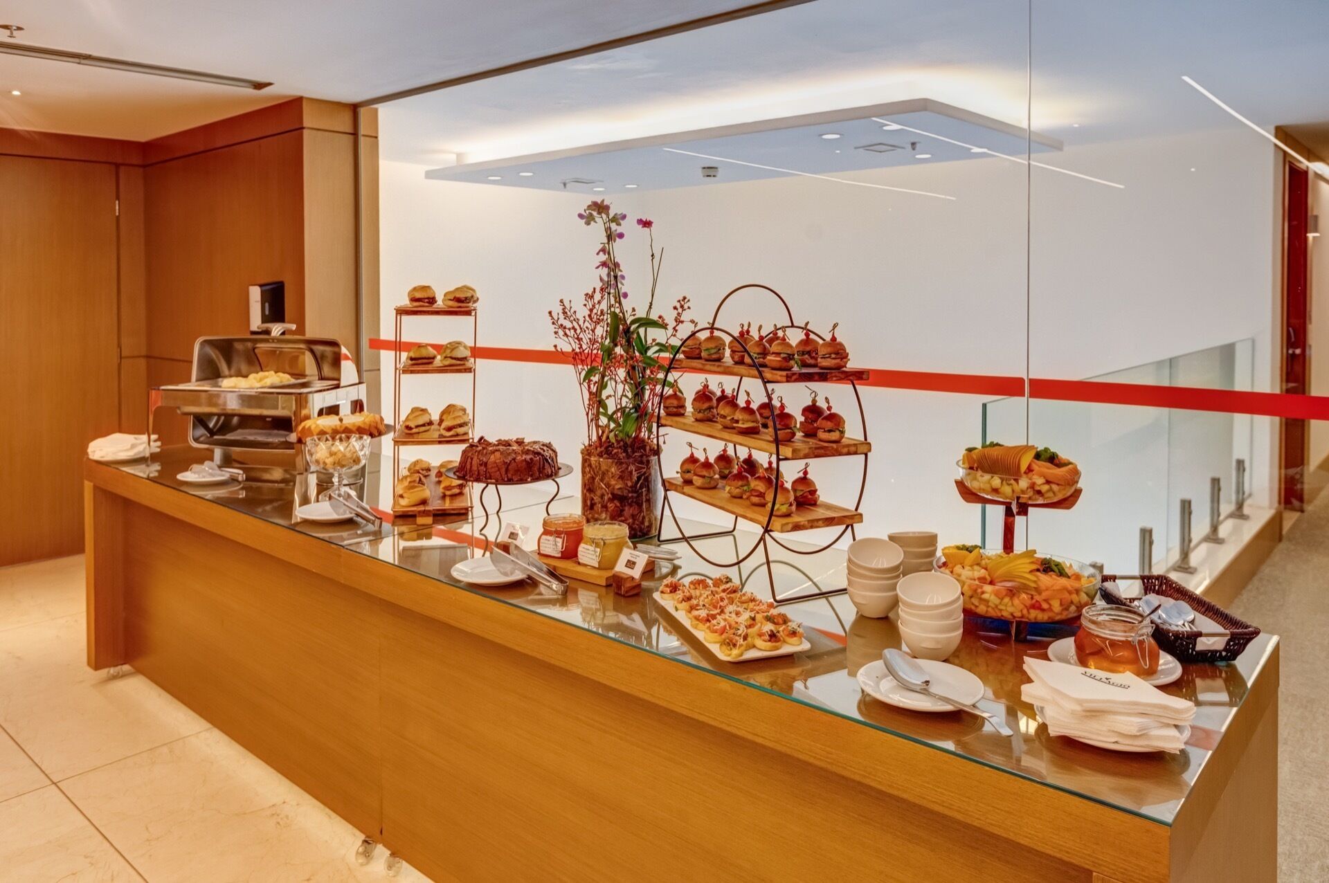 Buffet com diversos alimentos e uma vitrine de vidro.