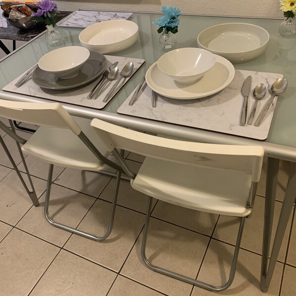 Enjoy meals in this dining area with a glass table and comfortable seating for four.