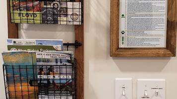 A wall-mounted display with various travel guides and maps, including a 'Floyd Virginia' guide and a 'New River Valley Trail Guide'.