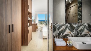 Une salle de bain moderne avec un grand miroir, un lavabo blanc et une douche.