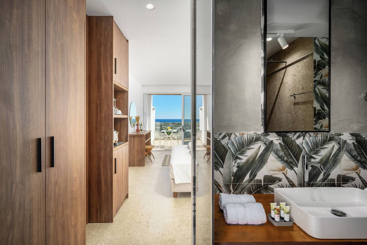Une salle de bain moderne avec un grand miroir, un lavabo blanc et une douche.