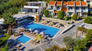 Un complexe hôtelier doté d’une grande piscine, de chaises longues et d’un espace extérieur couvert.