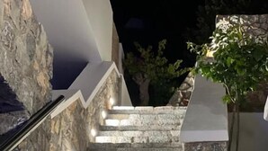 Un escalier en pierre, doté d’un système d’éclairage intégré, menant à l’entrée d’un bâtiment.