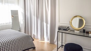 A hotel room with a bed, a desk with a mirror, a radiator, and a window with curtains. - N247 - Numana, wonderful four-room apartment in a strategic position (Maratta)