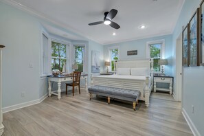 Quarto com cama, escrivaninha e cadeira.