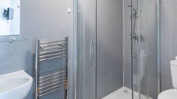 Une salle de bain moderne avec une douche à parois de verre, un lavabo blanc et des toilettes.