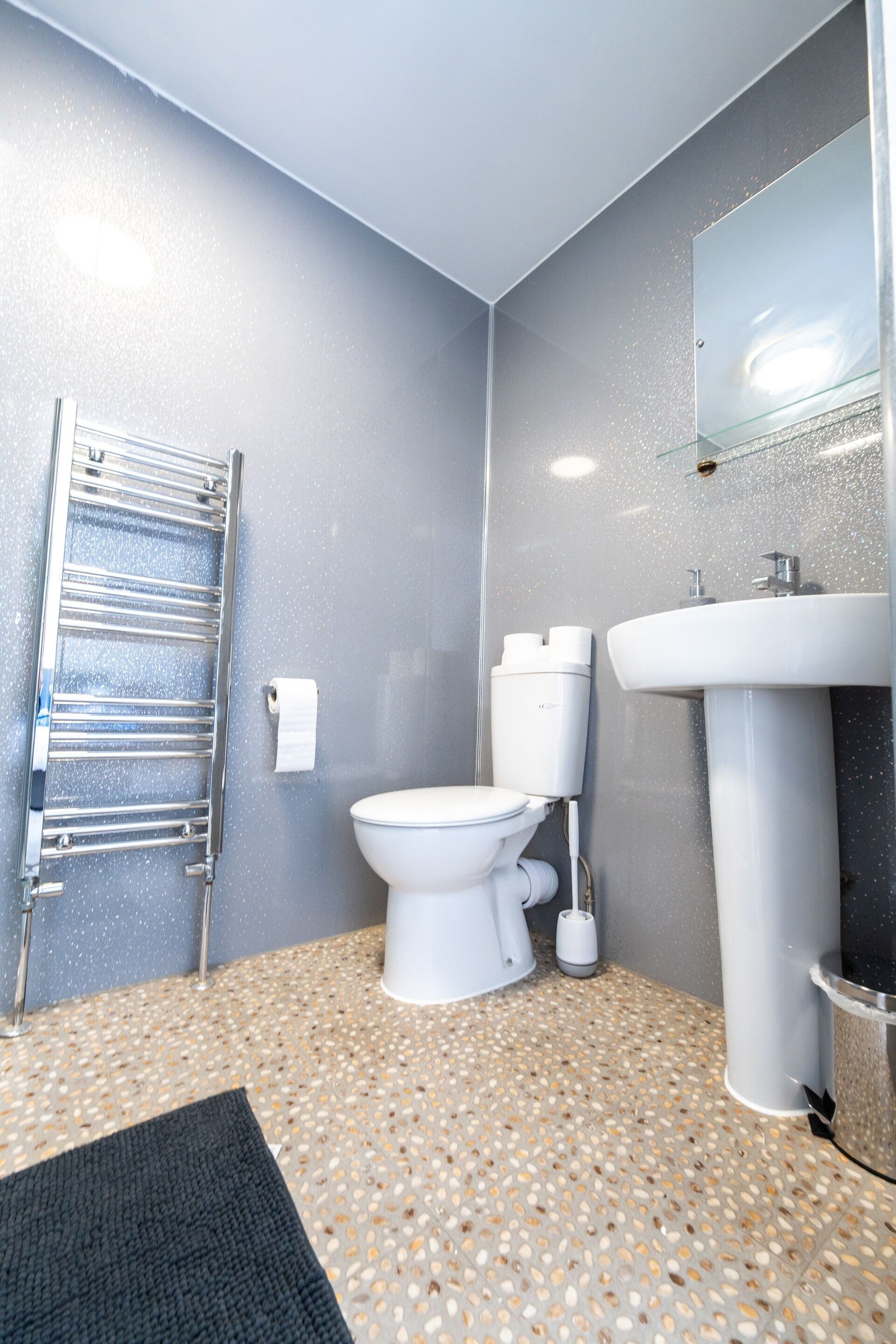 Ein Badezimmer mit Toilette, Waschbecken und Handtuchhalter.