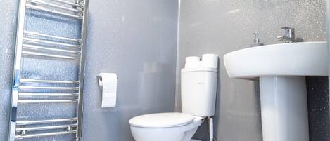 Ein Badezimmer mit Toilette, Waschbecken und Handtuchhalter.