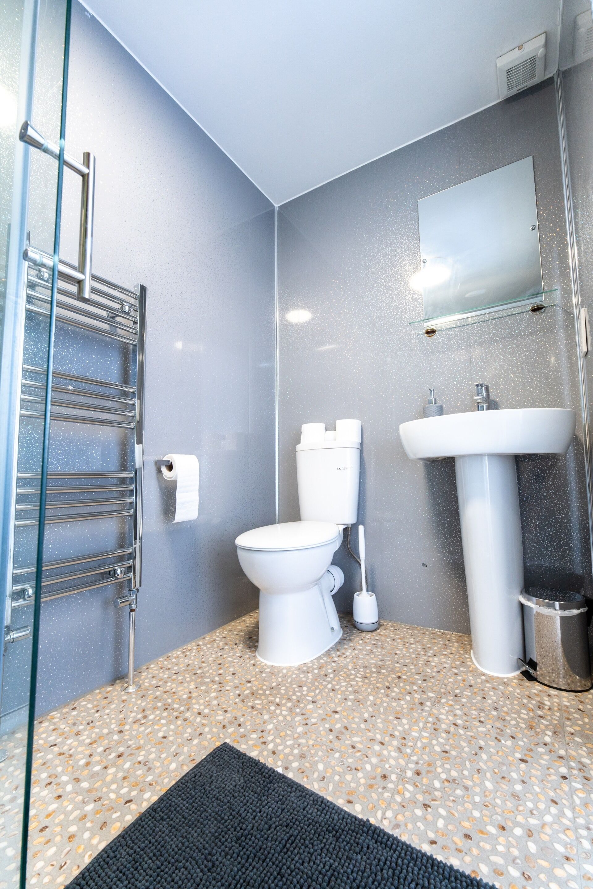 Een badkamer met toilet, wastafel en douche.