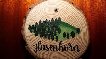 A wooden coaster with a painted landscape and the word 'Flasenkorn' on it.