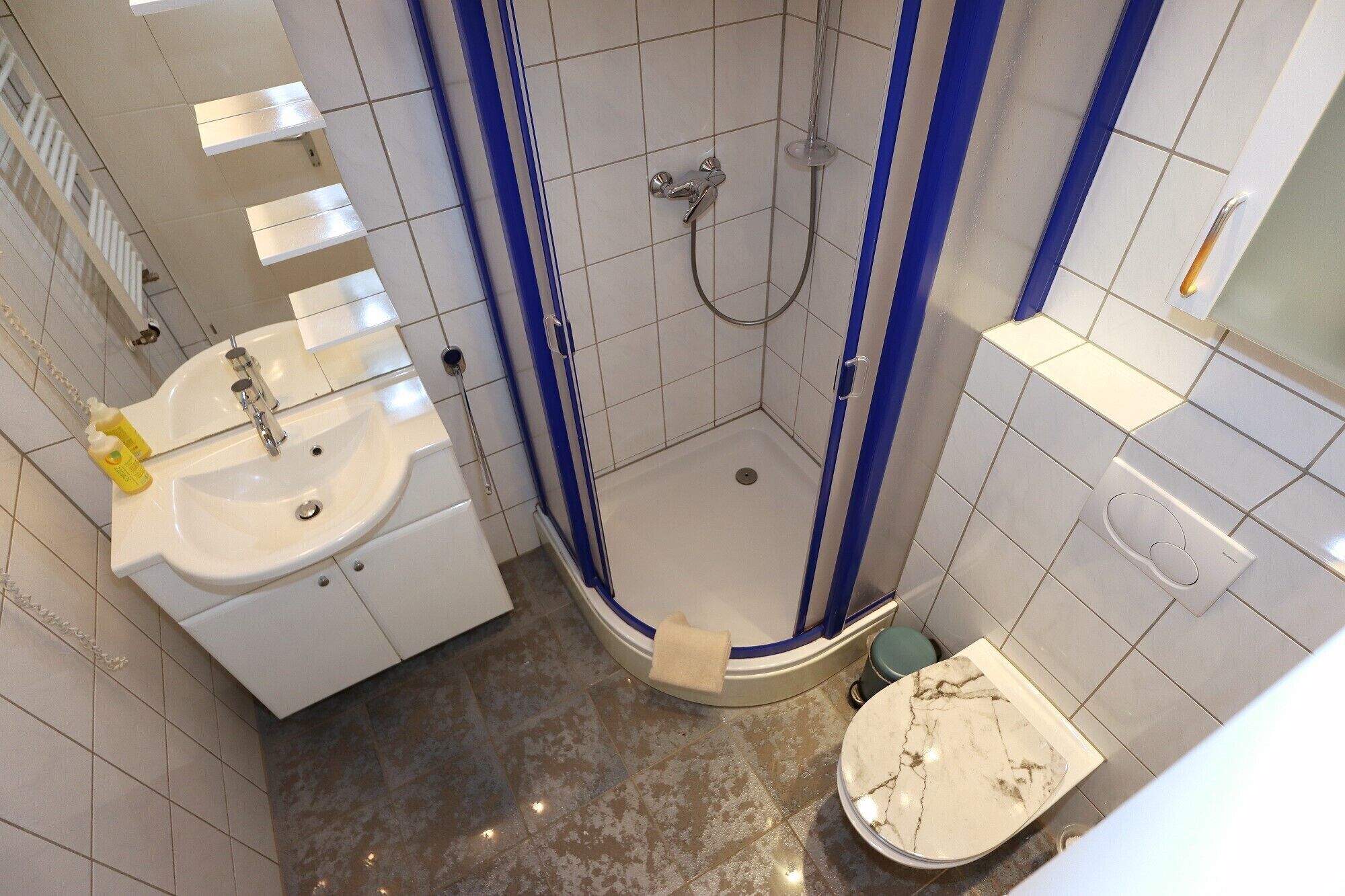 Ein modernes Badezimmer mit Dusche, Waschbecken und Toilette.