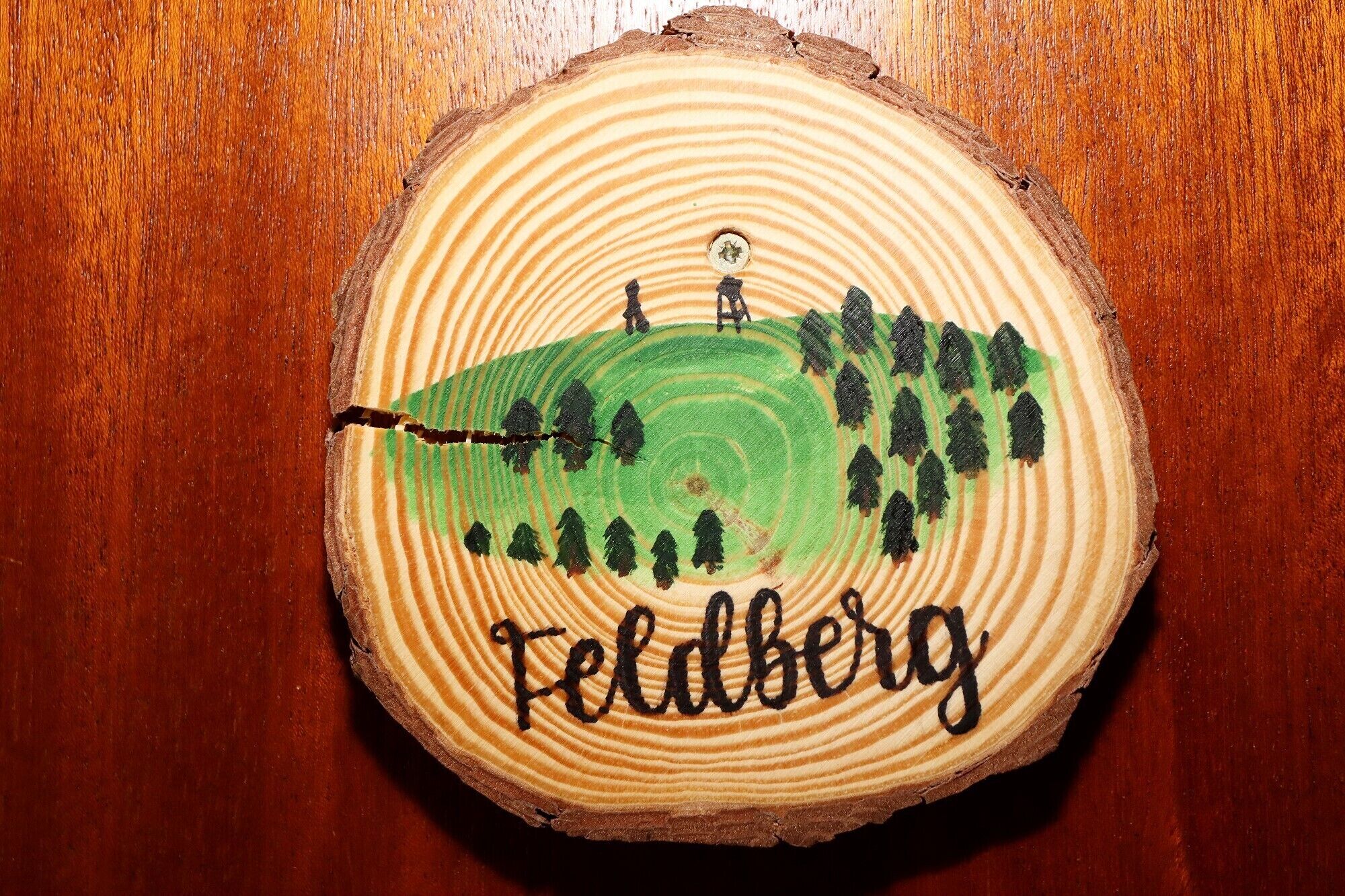 A wooden coaster with a painted landscape and the word "Feldberg" on it.