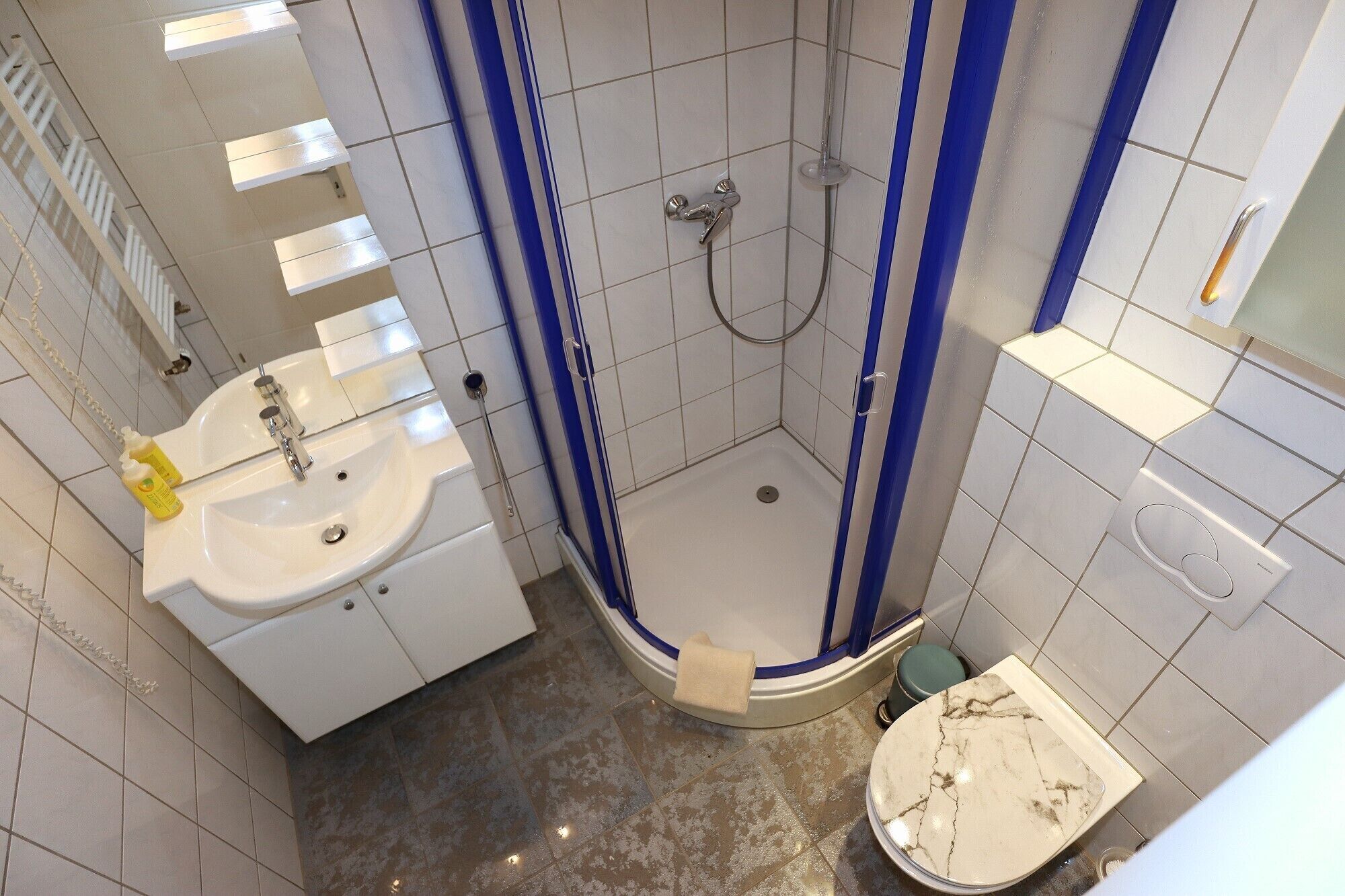 A bathroom with a shower, sink, and toilet.