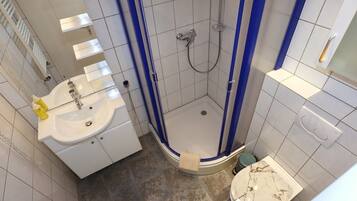 A bathroom with a shower, sink, and toilet.