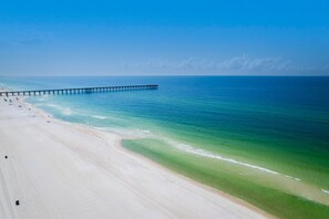 A beach with a pier extending into the ocean, clear skies, and calm waters. - Blue Sky Cottage in Seagrove Beach (Santa Rosa Beach)