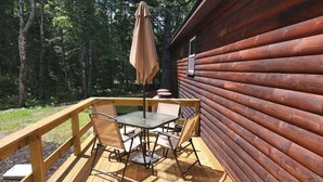 A wooden deck with a table and chairs, surrounded by a wooden fence.