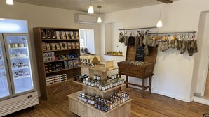 A store with wooden shelves, a display counter, and hanging items. - Chambres D'hôtes Terra Bella (Lecci)
