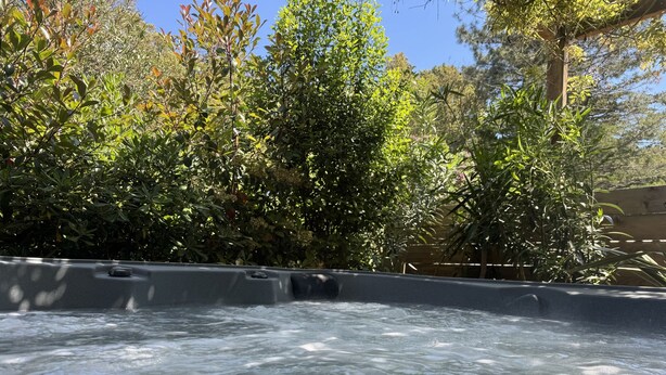 A hot tub surrounded by lush greenery and trees. - Chambres D'hôtes Terra Bella (Lecci)