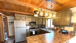 A kitchen with wooden cabinets, granite countertops, a stainless steel refrigerator, a gas stove, and a built-in oven.