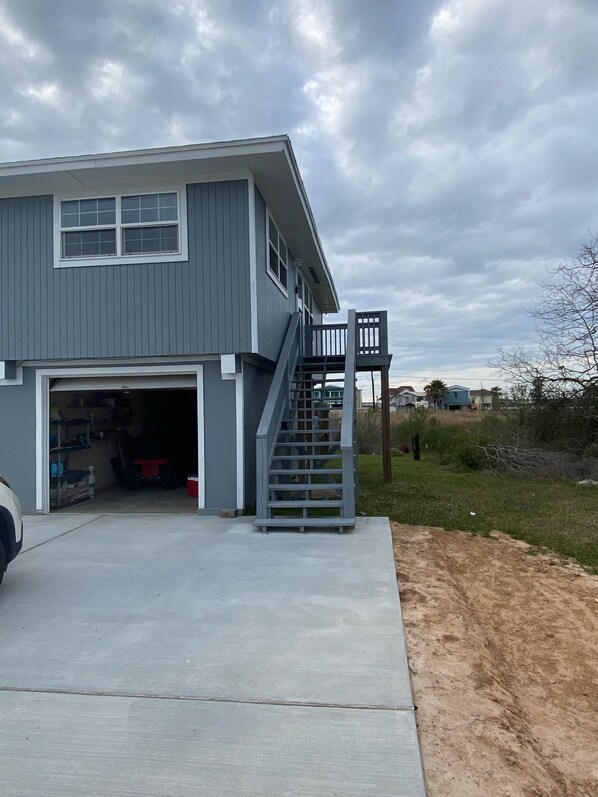 Ein zweistöckiges Haus mit Garage, Treppe und Auffahrt.