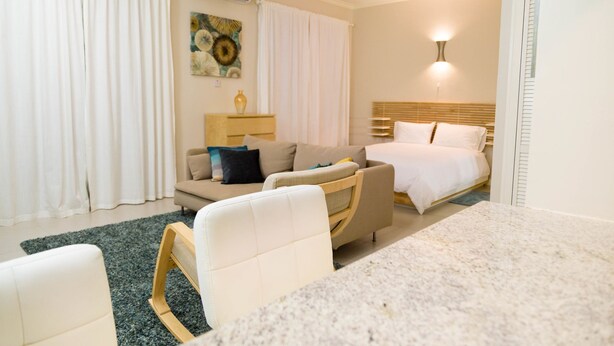 Une chambre d’hôtel équipée d’un lit, d’un canapé, d’une petite table et d’un appareil de climatisation.