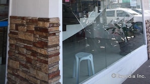 A building with a stone facade and a large glass window. - Check Inn Pension Arcade (Dumaguete)